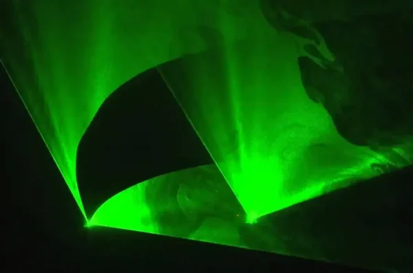 Bewegende groene laser vlakken, zichtbaar door rook van rookmachine.
