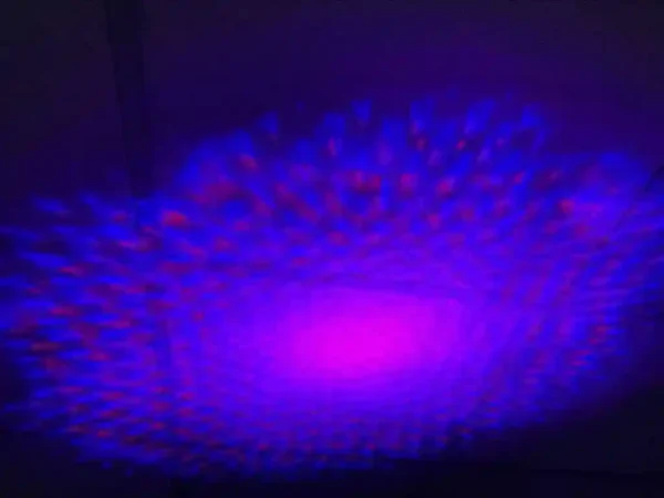 Paars-blauwe patronen op plafond in ringvorm door Spacelamp Showtec Dreamwave.