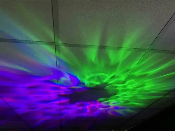 Paarse en groene patronen op plafond in ringvorm door Spacelamp Showtec Dreamwave.