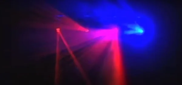 Discolamp met rode en blauwe lichtstralen, zichtbaar door rookmachine.